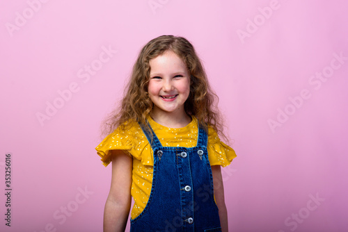 Happy carefree child emotions. Energetic joyful adorable little girl laughing at joke on pink background.