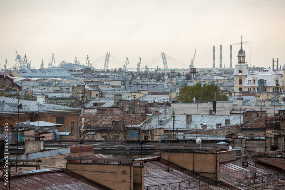 View of Saint Petersburg. Roofs of houses and a seaport on the horizon.