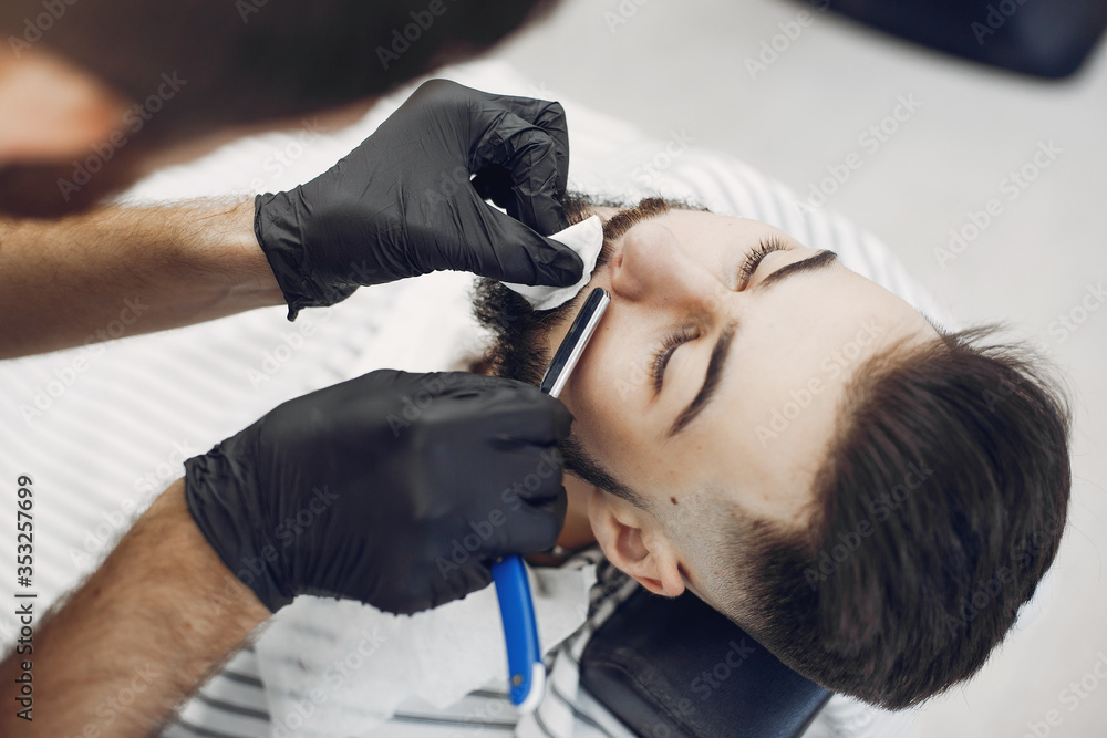 Man with a beard. Hairdresser with a client. Brunette in a barbershop Man with a beard. Hairdresser with a client. Brunette in a barbershop