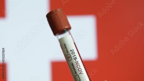 Corona virus or Covid-19 in Switzerland , sample blood tube with Switzerland flag on background
