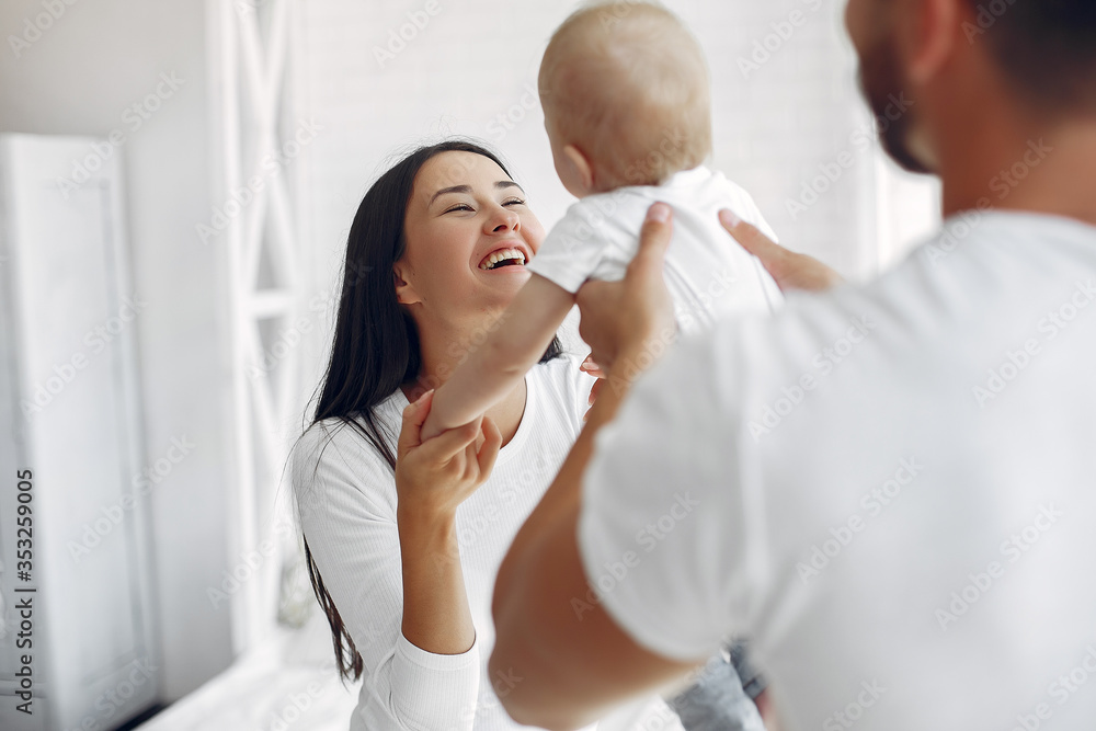 Cute family in a room. Lady in a white shirt. Little boy with parents Cute family in a room. Lady in a white shirt. Little boy with parents