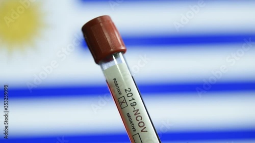 Corona virus or Covid-19 in Uruguay , sample blood tube with Uruguay flag on background