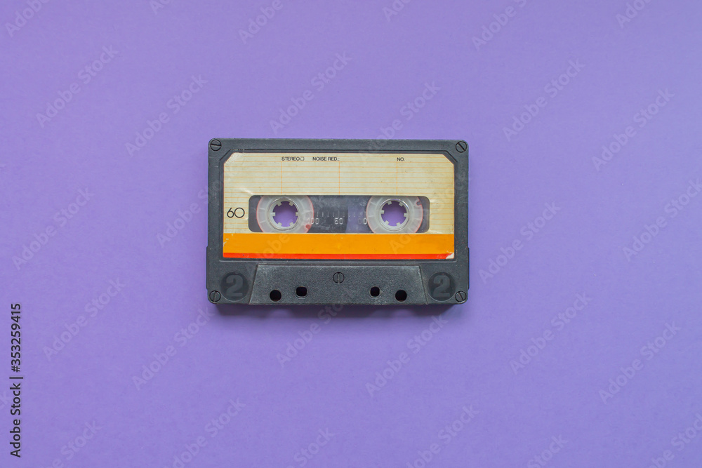 Obraz premium Retro audio tape cassette from 80s and 90s isolated on purple background. Old technology concept. Flat lay, top view with copy space.