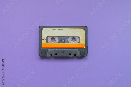 Retro audio tape cassette from 80s and 90s isolated on purple background. Old technology concept. Flat lay, top view with copy space.