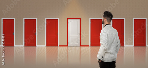 Valokuva Young man standing in front of many doors. Choice concept