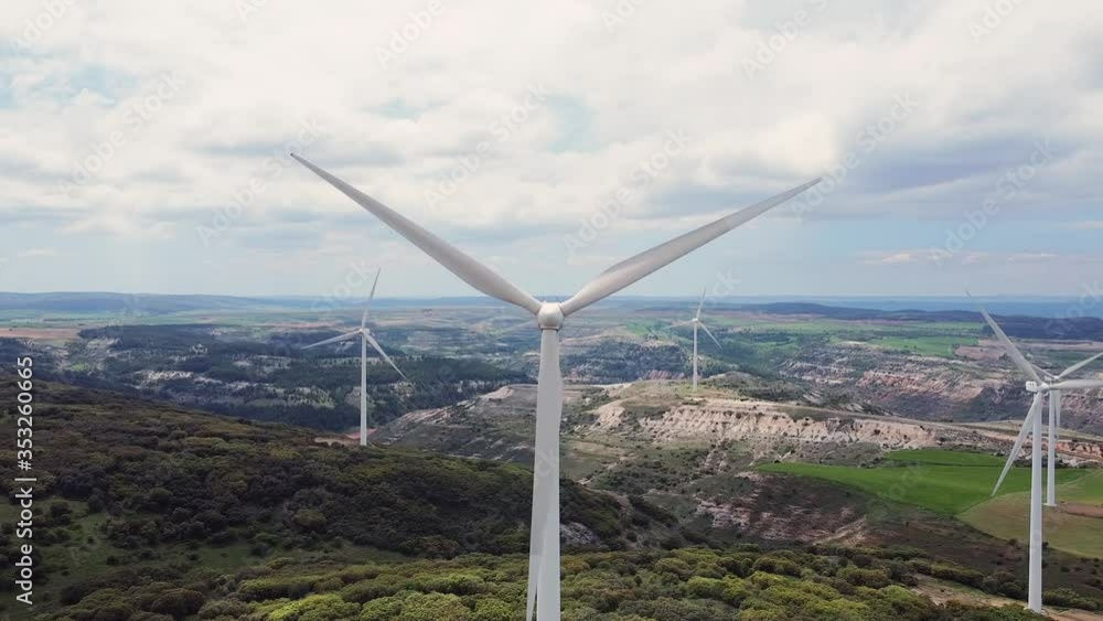 Aerial view of windmills farm for clean energy production on beautiful cloudy sky. Wind power turbines generating clean renewable energy for sustainable development . Aerial view of windmills farm for clean energy production on beautiful cloudy sky. Wind power turbines generating clean renewable energy for sustainable development .
