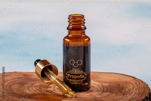 A bottle of propolis on piece of wood Propolis Drop Oil drop falling photo