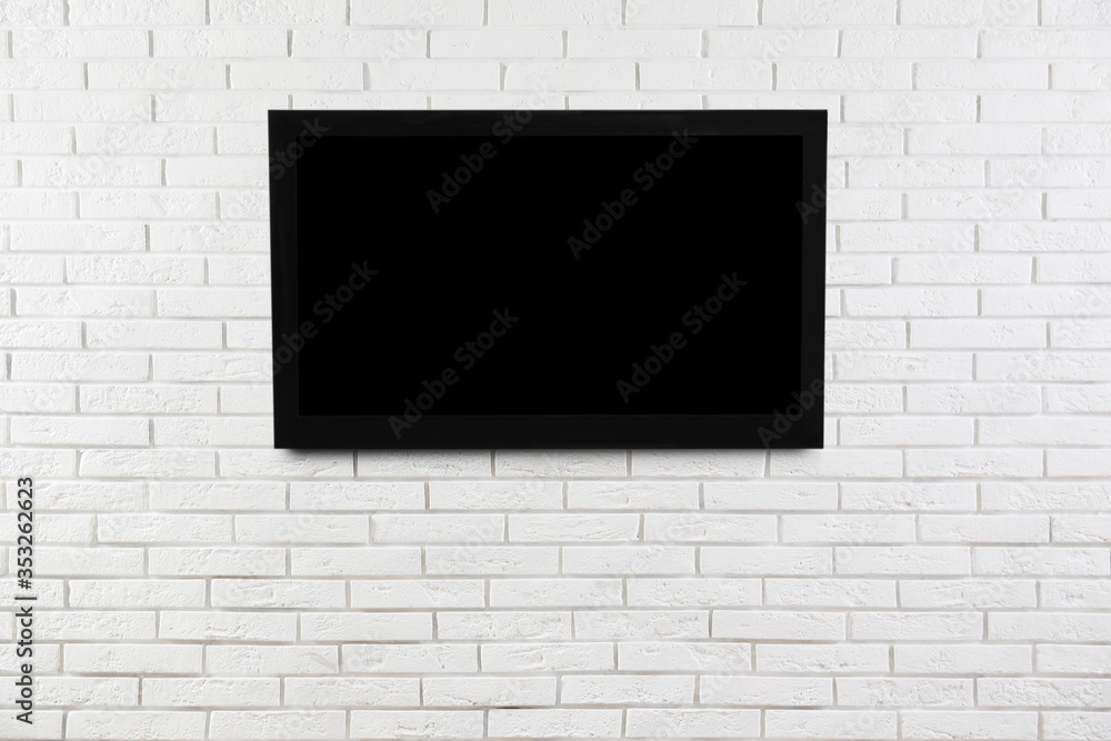 Modern TV on white brick wall. Space for design Modern TV on white brick wall. Space for design
