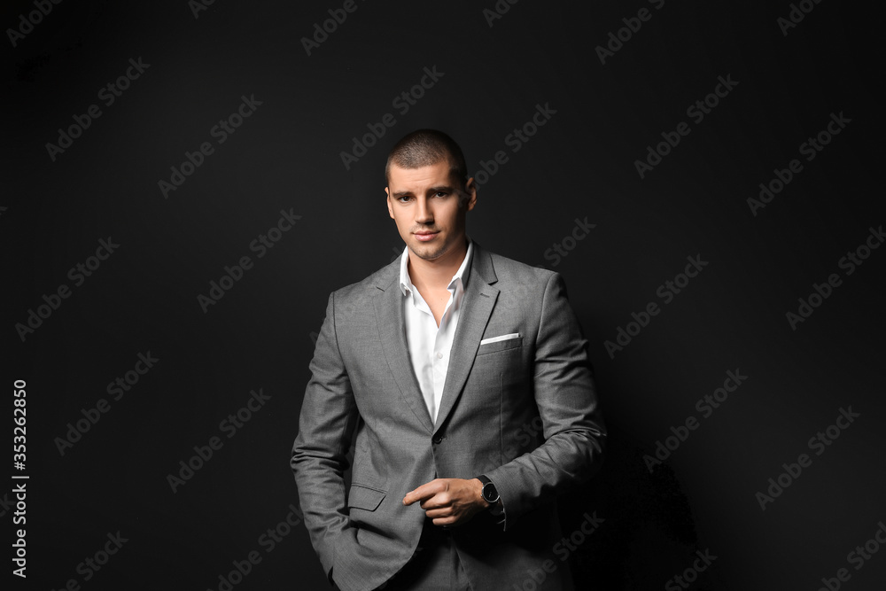 Handsome young man in elegant suit on dark background Handsome young man in elegant suit on dark background