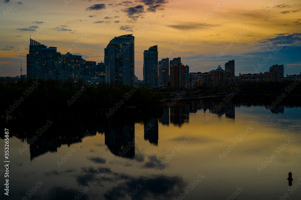 Ukraine, Kiev, April 24, 2020, evening view of the Obolon embankment of the city across the Dnieper River, the Obolon residential area, high-rise apartment buildings in the evening
