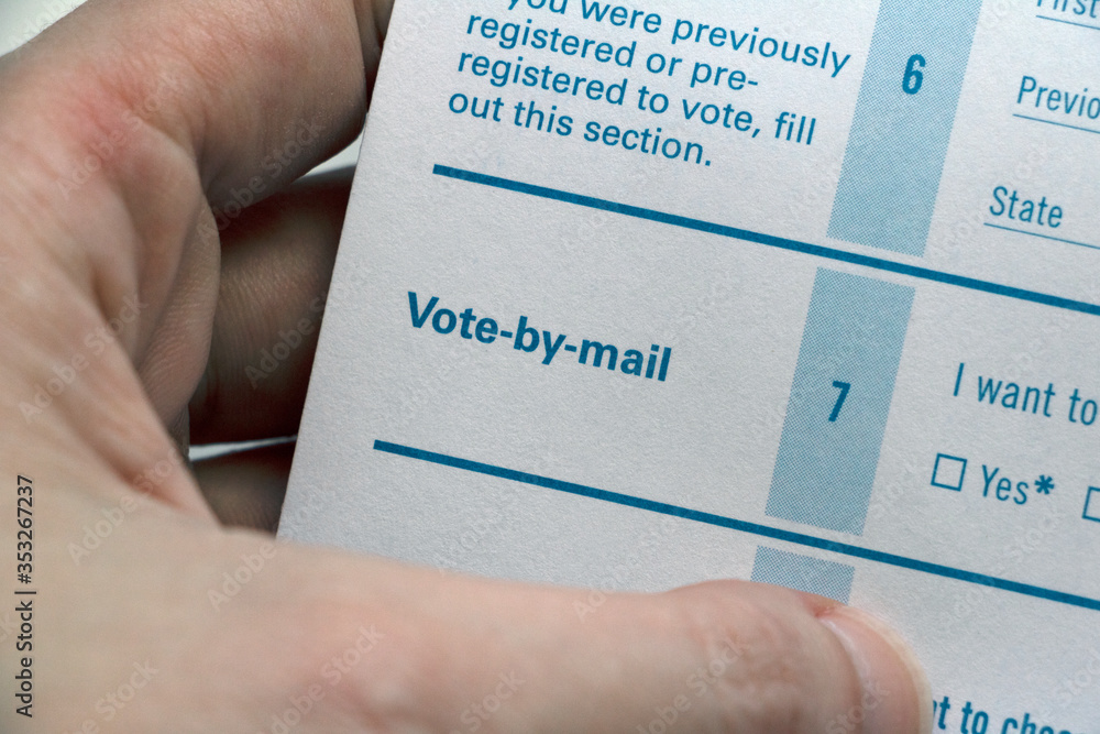 Hand holding Voter Registration form, closeup on Vote-by-mail Hand holding Voter Registration form, closeup on Vote-by-mail