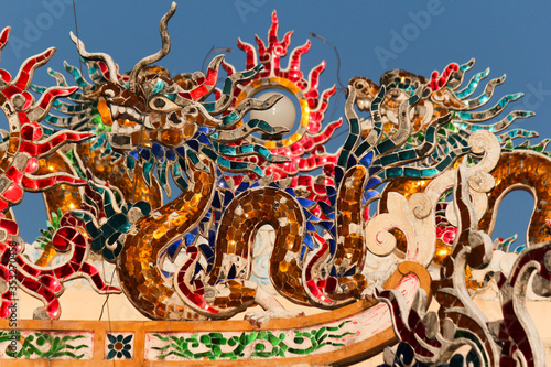 colorful glass mosaic dragon images as roof top decoration in a chinese temple in the city of savannakhet lao PDR