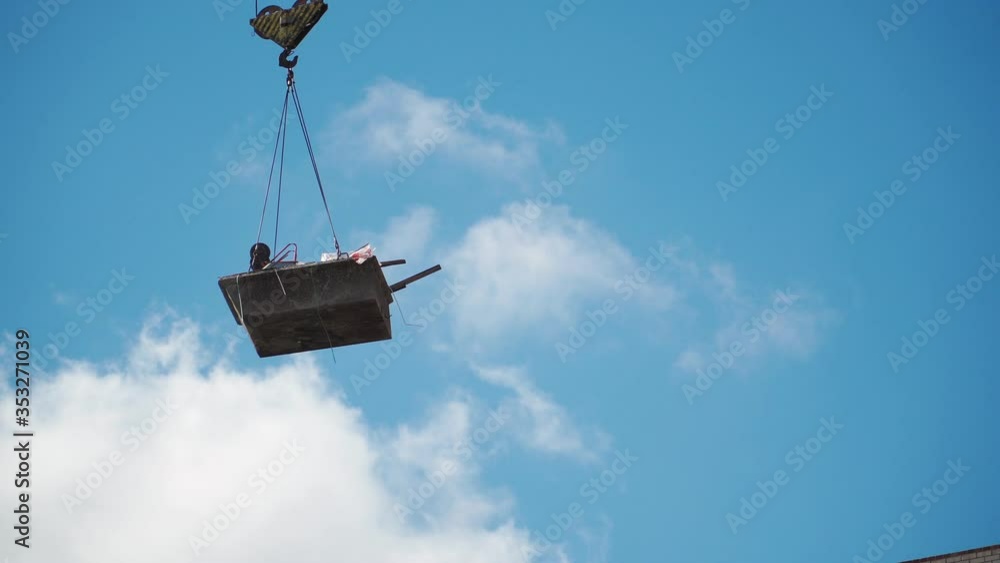 The work of a construction crane. Building on sky background. Close up The work of a construction crane. Building on sky background. Close up