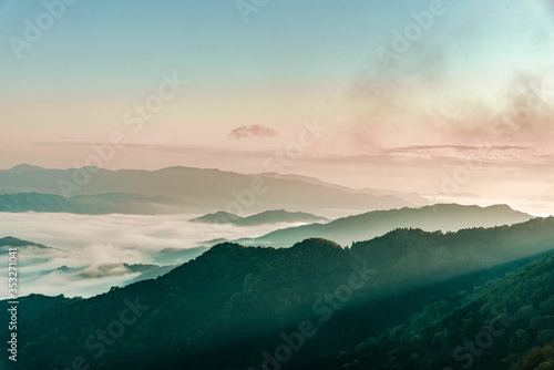 京都・新緑の山影に尾根からの朝もやと雲海