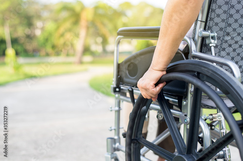 Close up of hands disabled woman sitting on wheelchair at outdoor