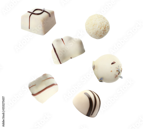 Falling different chocolate candies on white background