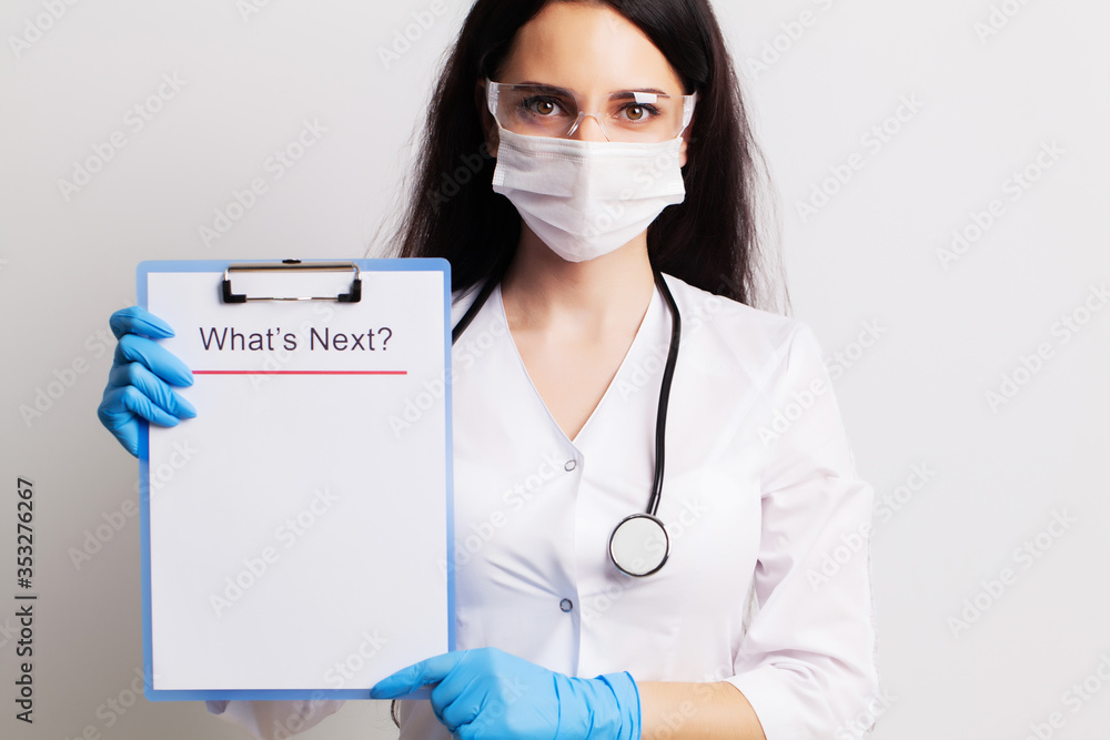 Doctor in a gloves, mask and glasses holds sheet with text what's next. Doctor in a gloves, mask and glasses holds sheet with text what's next.