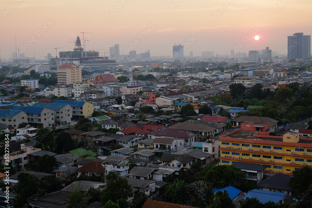 View from above roofs of village houses during sunset. Residential buildings in Bangkok Downtown, Thailand. Architecture landscape background