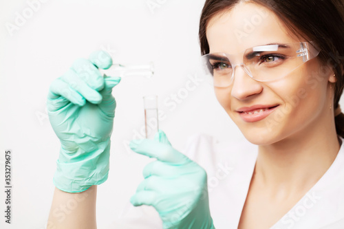 Medicine concept  doctor female in clinic holding test tubes with experimental vaccine