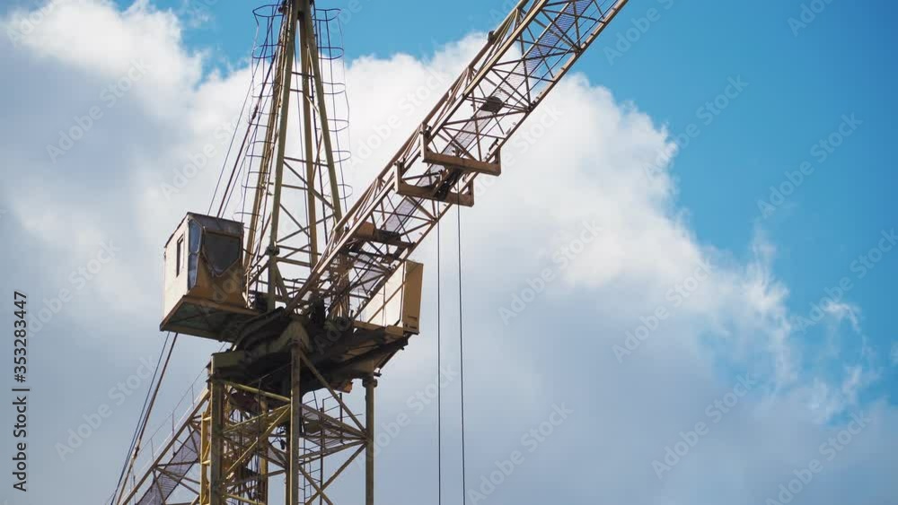 The work of a construction crane. Building on sky background. Close up The work of a construction crane. Building on sky background. Close up
