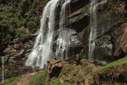 Hiker sit in front of a waterfall deep in the jungle - Sri Lanka, Nuwara Eliya. Bomburu Ella waterfall photo