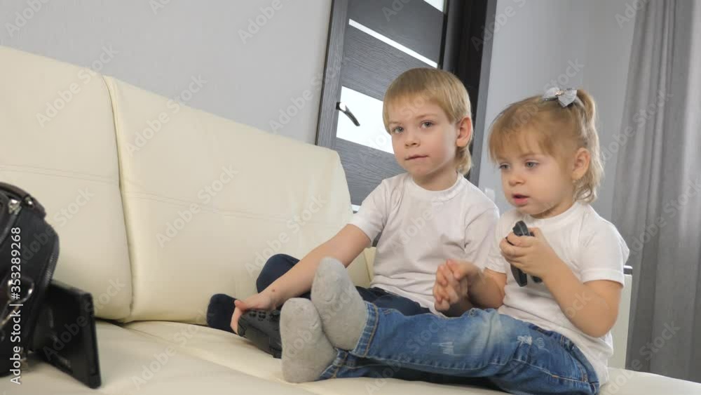 kids a boy and a girl are playing a portable set-top box in a TV controller. children play console in gamepads teamwork. happy family little boy and girl have lifestyle fun online games kids a boy and a girl are playing a portable set-top box in a TV controller. children play console in gamepads teamwork. happy family little boy and girl have lifestyle fun online games