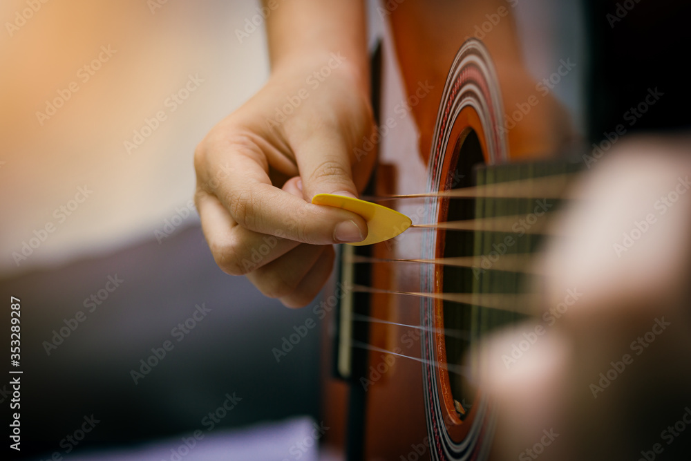 Fototapeta premium Close up of young girl hand playing guitar