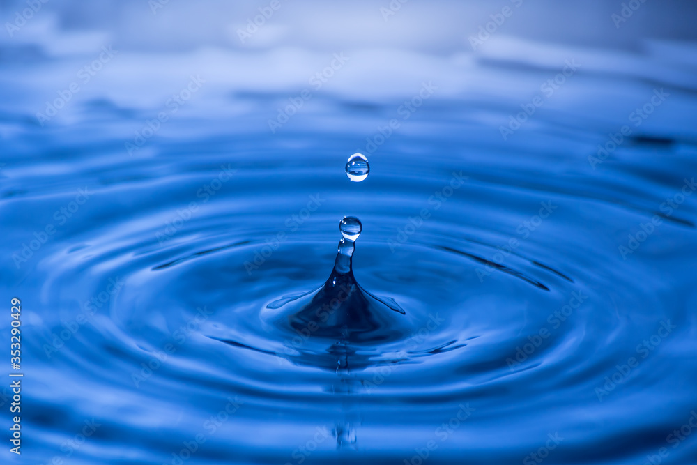 Water drop close up of in a blurred blue background Water drop close up of in a blurred blue background