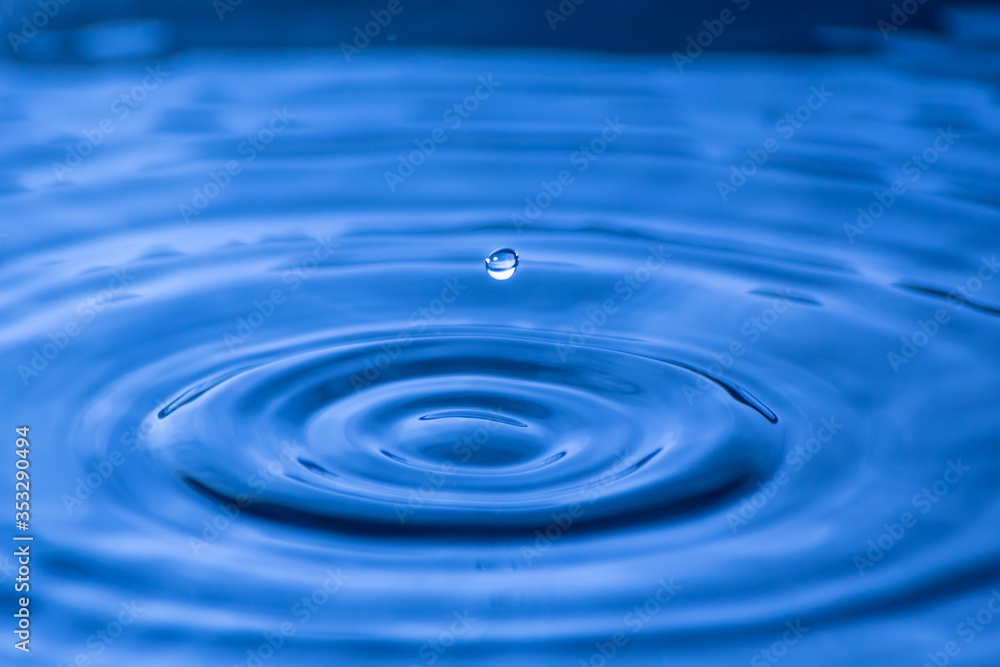 Water drop close up of in a blurred blue background Water drop close up of in a blurred blue background