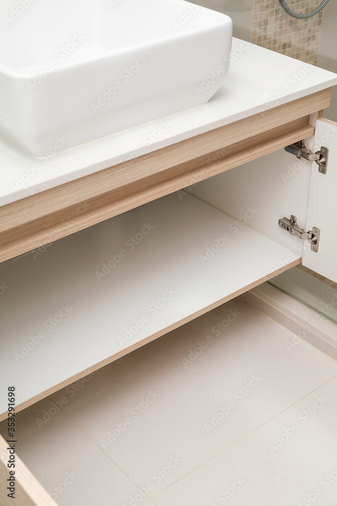 Fototapeta premium detail of cupboard or wardrobe under sink in bathroom, built-in furniture in modern condominium