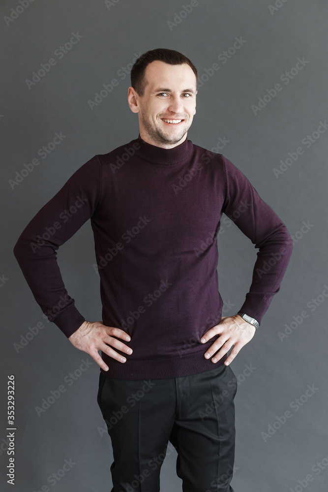 man in a violet sweater on a gray background