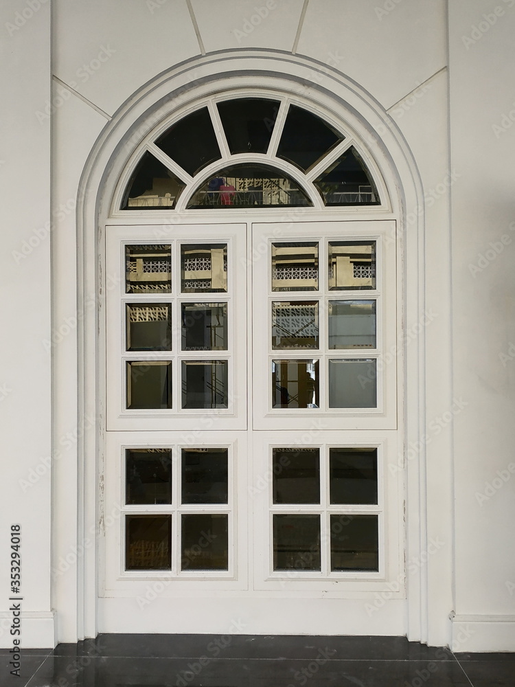 Antique white door in the white wall, classic decorative architectural design Antique white door in the white wall, classic decorative architectural design