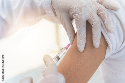 The doctor is currently treating patients by injecting arms. Vaccination or medication to prevent and treat viruses.