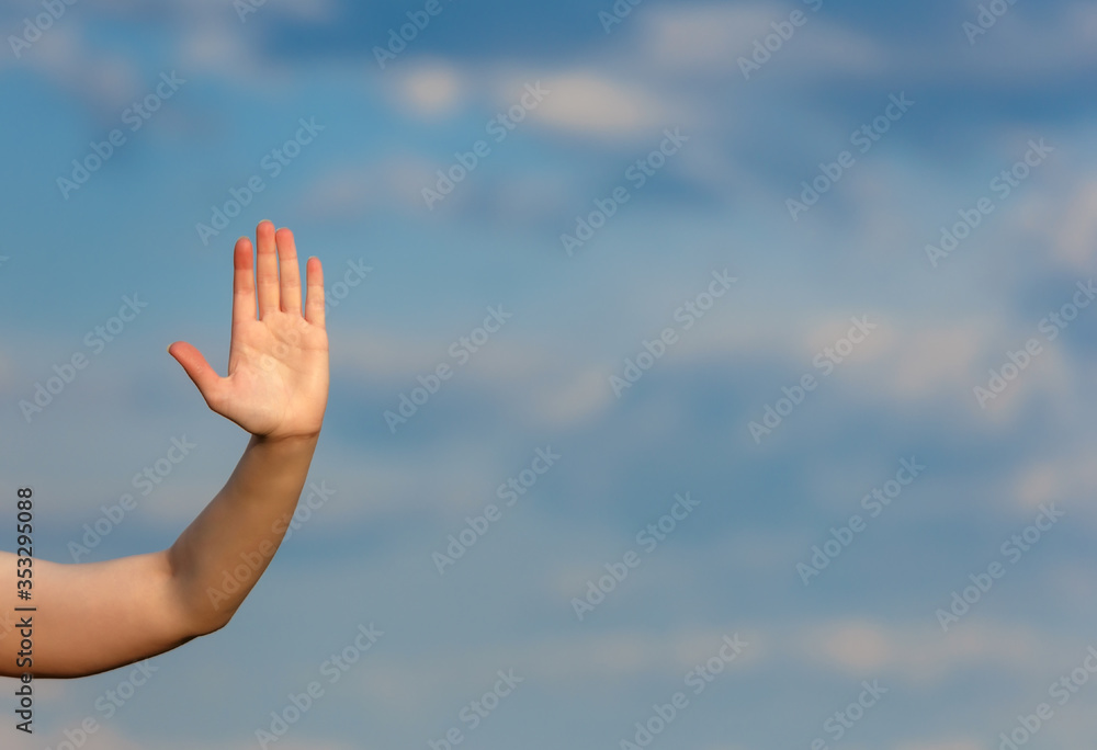 Woman hand over clouds blurred background doing the stop gesture Woman hand over clouds blurred background doing the stop gesture