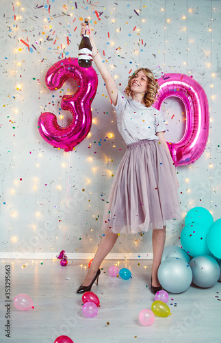 Happy girl with pink balloons celebrates her birthday on 30 years