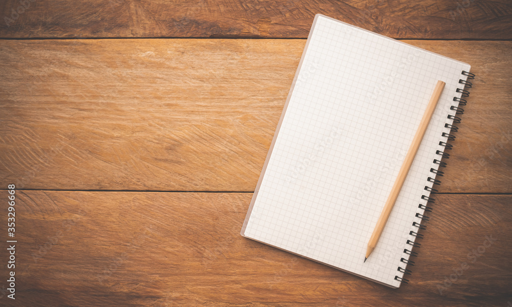 White notebooks and pencil laying on a wooden table White notebooks and pencil laying on a wooden table