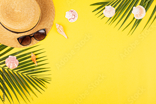 Summer composition with female fashion outfit. tropical palm leaves, straw hat, seashells on yellow background. Flat lay, top view, overhead, mockup, template, copy space