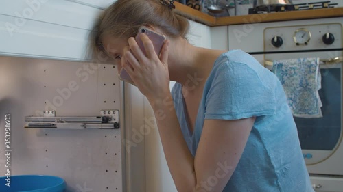 Close up beautiful woman calling plumbing master by smartphone. Plumbing in need of repair. Housekeeping