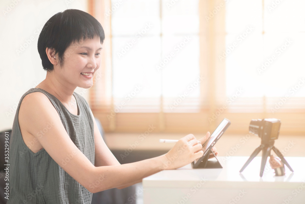 Asian mature adult woman vlogger or blogger influencer and content creator, recording podcast viral clip work at home, share on social media live streaming Internet online business channel. Asian mature adult woman vlogger or blogger influencer and content creator, recording podcast viral clip work at home, share on social media live streaming Internet online business channel.