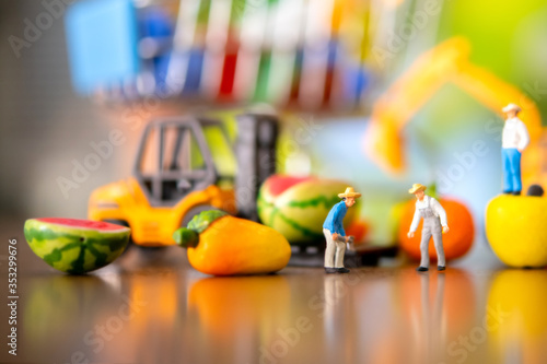 Miniature people of worker in farm loading fresh fruits and vegetable to supermarket warehouse . Fresh food business concept