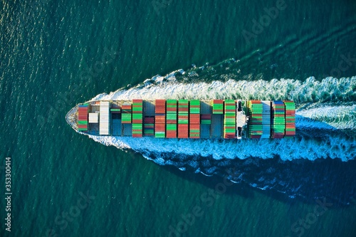 Aerial shot of an industrial ship sailing in the turquoise ocean