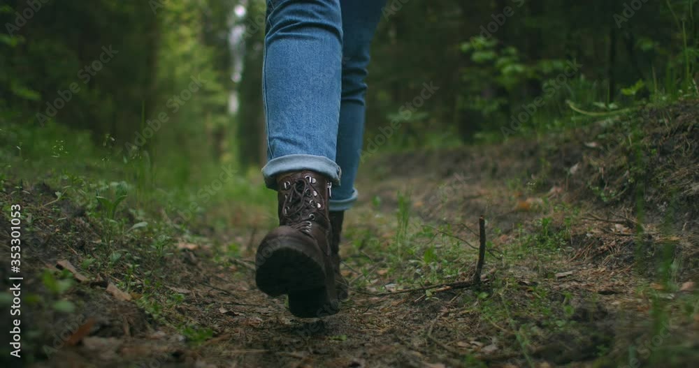 Close up of women legs hiking steep terrain in slow motion. Feet in Hiking Boots Walking on Autumn Road. woman feet tracking on fall day outdoors, walking through woodland Close up of women legs hiking steep terrain in slow motion. Feet in Hiking Boots Walking on Autumn Road. woman feet tracking on fall day outdoors, walking through woodland