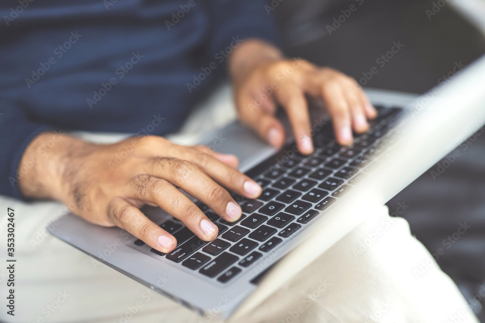 lifestyle man close up hand keyboard sit work on sofa using a laptop computer to work home and search information social network online. lifestyle man close up hand keyboard sit work on sofa using a laptop computer to work home and search information social network online.