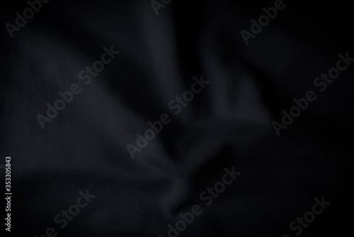 Abstract folded black clothes mesh background . Dark tone wallpaper