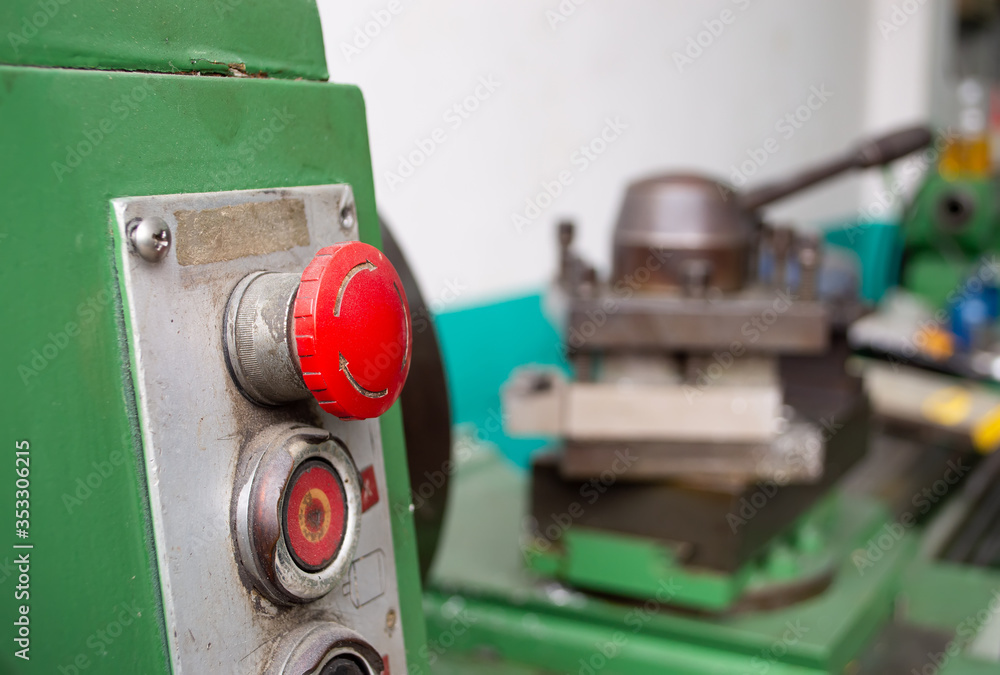 close up red emergency button of green lathe machine
