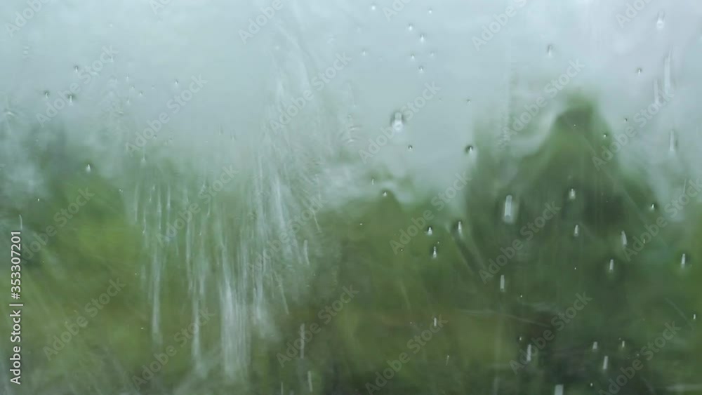 Rain drop on a window inside a house or a car and with green nature in the background. Season winter feelings. Rain drop on a window inside a house or a car and with green nature in the background. Season winter feelings.