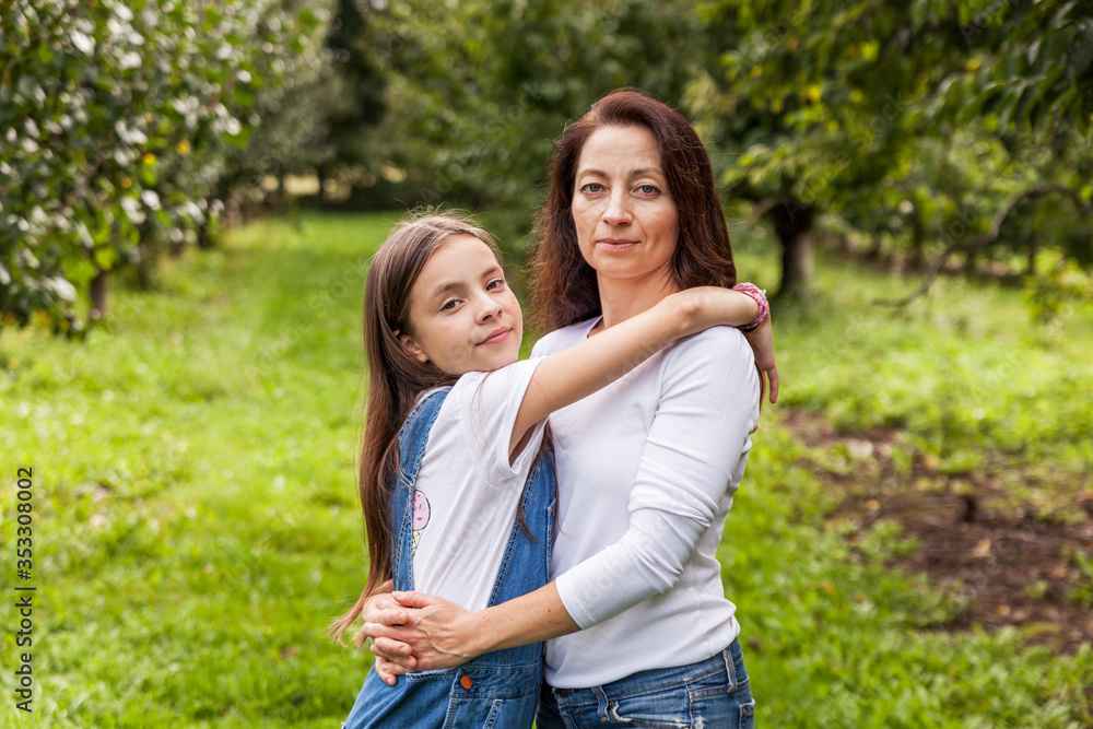 Portrait of little girl and beautiful mother in organic apple orchard happy and having fun. Portrait of little girl and beautiful mother in organic apple orchard happy and having fun.