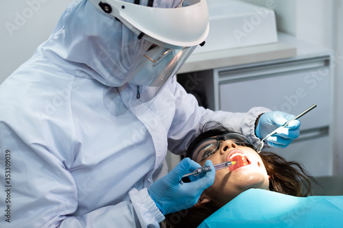 Dentist about to apply anesthesia to young female patient