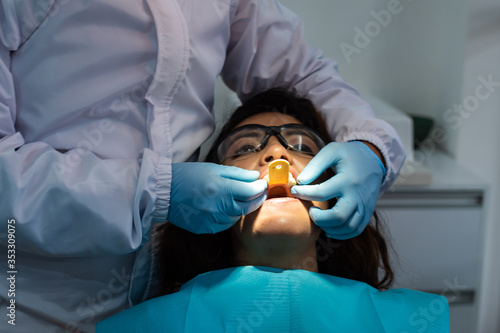 Dentist taking a dental impression of a young female patient