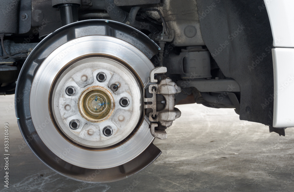 Rear wheel hub and car disk brake on background, detail of the rear wheel hub